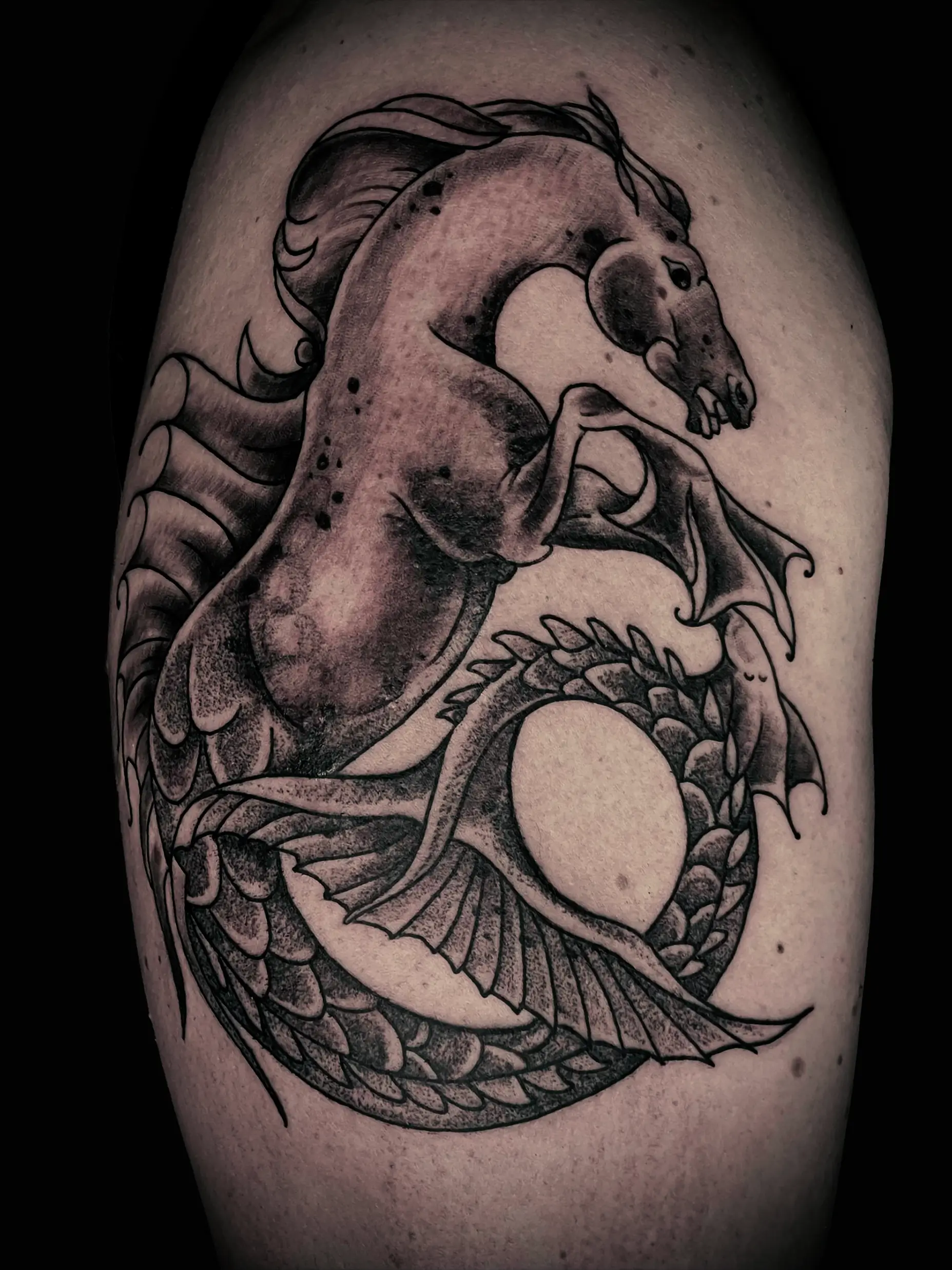 Black and grey tattoo of a rearing horse merging into a dragon, detailed shading and dynamic composition on upper leg.